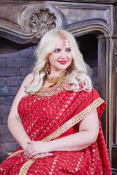Smiling blonde woman in red dress sits at - paha_l