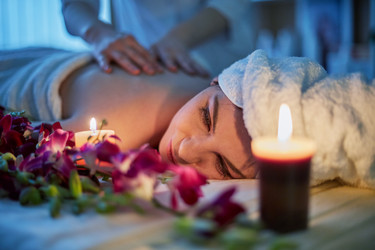 Woman lies on couch with flowers and gets massage - paha_l