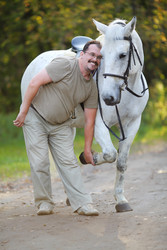 Happy man plays with beautiful white horse in - paha_l