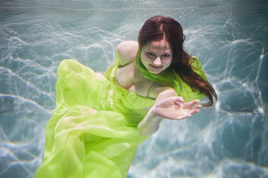Smiling young woman in yellow-green dress poses in - paha_l