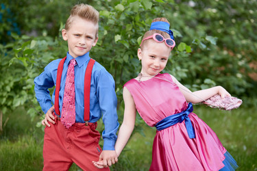 Boy and girl dressed in red and blue costumes pose - paha_l