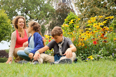 Mother, son and daughter sitting on the grass in - paha_l