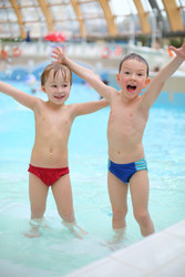 Two happy little boys raised their hands in a pool - paha_l
