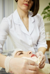 Beautician apply cosmetic mask with wooden spatula - paha_l