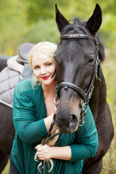 Blonde woman in green clothes and chestnut horse - paha_l