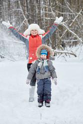 Mother and little son stand under snow powder in - paha_l
