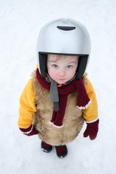 Little girl in a fur vest and helmet is looking up - paha_l