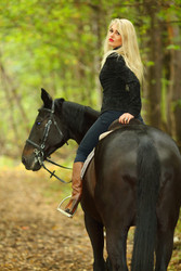 Blonde beautiful woman in black rides horse in - paha_l