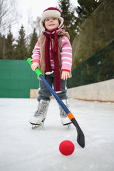 Happy little girl on skates with a hockey stick - paha_l