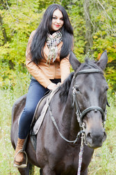 Black-haired woman in brown jacket sits on bay - paha_l