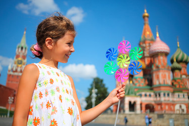 Young happy girl with pinwheel stands on Red - paha_l