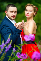 мужчина в костюме и молодая женщина в красном платье позируют с - paha_l