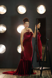 Pretty brunette woman in red long dress poses near - paha_l