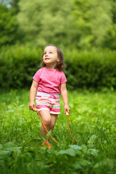 Little cute girl with skipping rope looks up in - paha_l