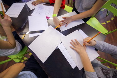 Children encircle hand with a pencil on a sheet of - paha_l