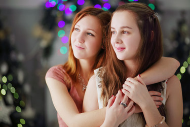 Two happy girls teenagers hug near christmas trees - paha_l