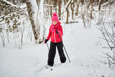 Girl slides on skis through the snowy forest - paha_l