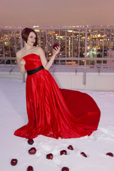 Young woman in red dress stands on snowy roof, red - paha_l