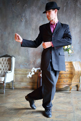 Young handsome man in suit and hat dances tango in - paha_l