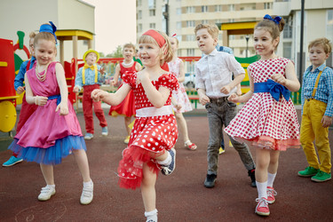 Ten children dance at playground in courtyard - paha_l