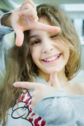 Little smiling girl shows frame with her fingers - paha_l