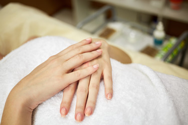 Hands of woman wrapped in towel and lying on her - paha_l