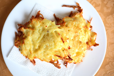 Yellow fresh potato pancakes are on white plate on - paha_l