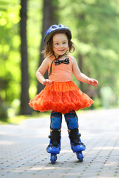 Little girl in skirt and helmet roller-blades and - paha_l