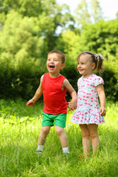 Little laughing girl and boy stand on fresh green - paha_l