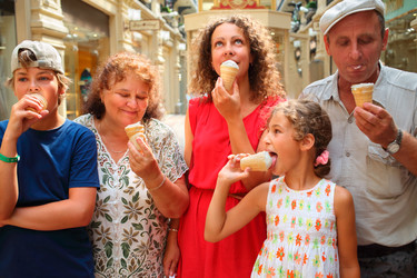 Happy family eating ice cream walking through - paha_l