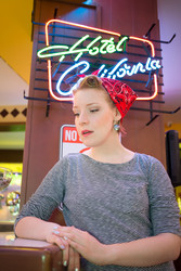 Young girl in striped vest near neon signboard in - paha_l
