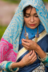 Sad indian woman stands and looks down in bright - paha_l