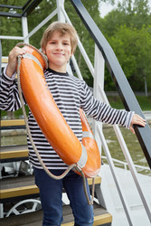 Smiling boy in striped vest with lifebouy ring - paha_l