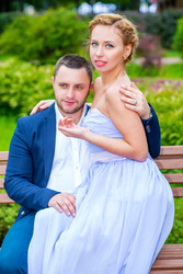 мужчина и женщина обнимаются и сидят на деревянной скамье в - paha_l