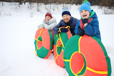 Mother, father, son pose with snow tubes in winter - paha_l