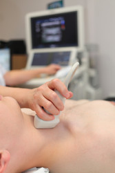Doctor examining patient with thyroid ultrasound, - paha_l