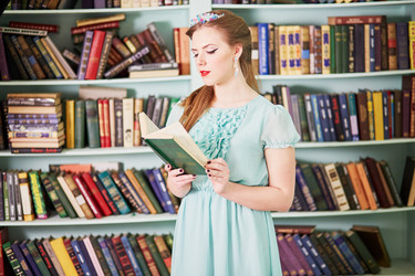 молодая женщина в зеленом платье читает книгу, стоя у - paha_l