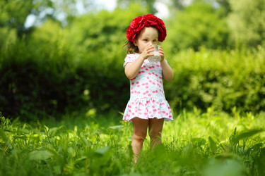 Little cute girl in wreath drinks milk in summer - paha_l