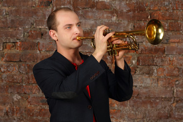 Young handsome man in suit plays trumpet in studio - paha_l
