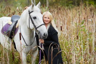 Blonde woman holds by bridle white horse among the - paha_l