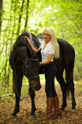 Blonde beautiful woman and black horse in green - paha_l