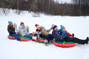 Six happy people sits on four snow tubes in snow - paha_l