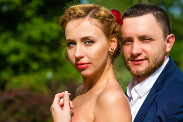 мужчина в костюме и молодая женщина обнимаются и позируют летом - paha_l