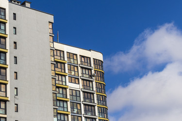 • Modern apartment building with Belarusian flag under blue sky. Outdoors - Pazemin
