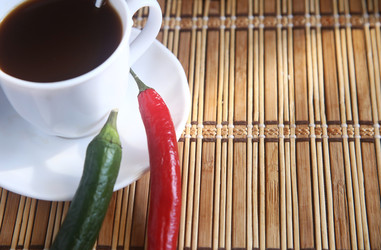 Белая чашка черного кофе с зернами, палочками корицы и шоколадными печеньями на столе - ZemLenik_photoclb