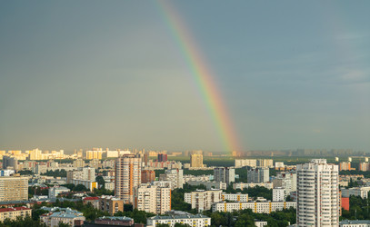 москва, россия. радужная дуга опускается после дождя над юго-восточным административным округом, контрастируя с плотными жилыми башнями и зеленым пологом района кузьминки - NikitaMaykov