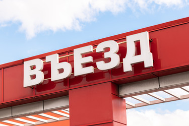 Белая объемная вывеска «Въезд» на красном фасаде здания - sergeycanon