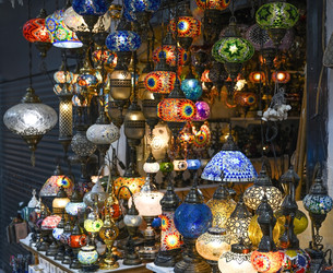 Сcollection of intricately patterned mosaic glass lanterns hangs in a market - alkir