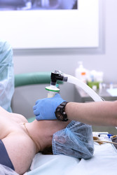 анестезиолог держит на пациенте маску анестезиологического аппарата. кислород и анестетик доставляются по дыхательному контуру - RusAKphoto