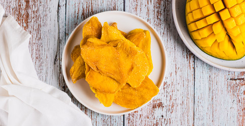 вкусное, сладкое, нарезанное ломтиками манго на тарелке на столешнице посмотреть веб-баннер - Elena Rui